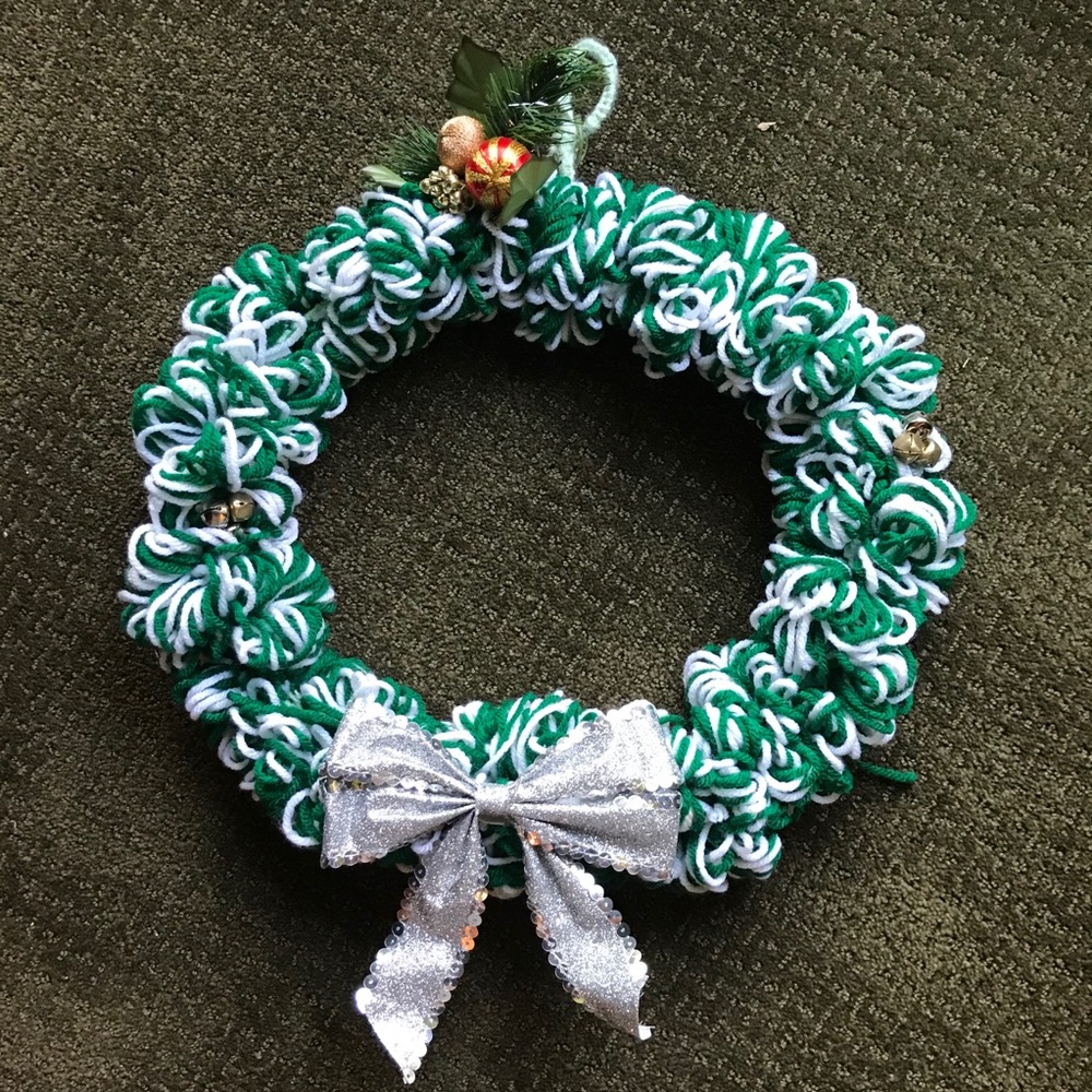Homemade Green & white yarn wreath, bells on sides, mistletoe on top